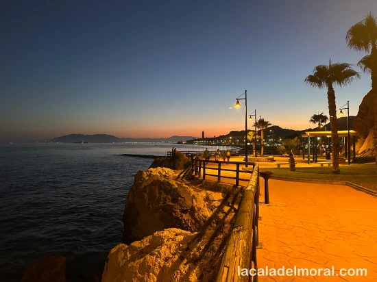 Atardecer junto al santuario de la Virgen del Carmen en La Cala del Moral, con tonos cálidos sobre el mar y los acantilados.