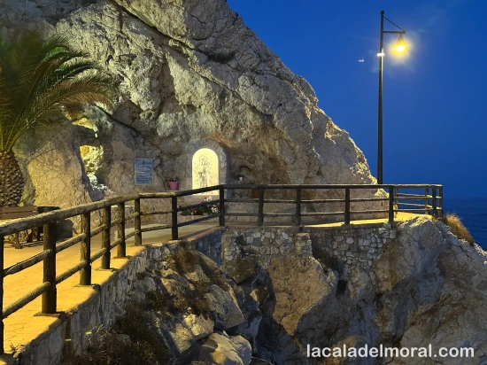 Vista del santuario de la Virgen del Carmen en La Cala del Moral al atardecer, con cielo cálido sobre los acantilados.